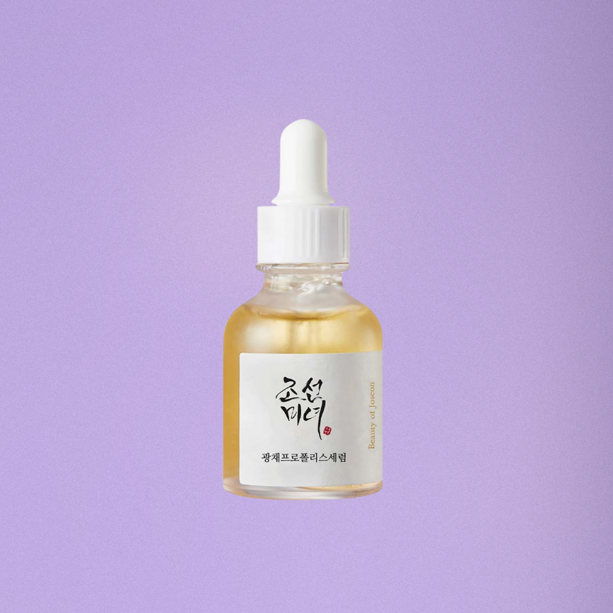 Skincare serum bottle with dropper on a purple background